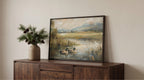 a wooden cabinet with a framed painting of ducks swimming in a pond, placed on top of it. The painting is set against a white wall, creating a serene and peaceful atmosphere.