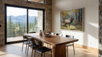 a dining room with a large wooden table and chairs, a painting of a deer on the wall, and a view of a forest through a large window.