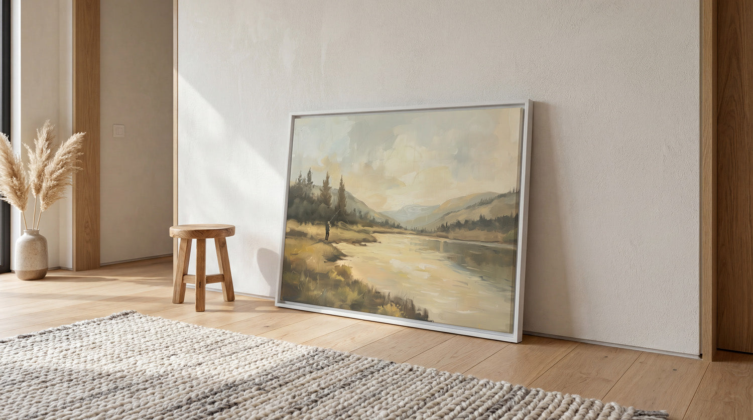 a large landscape painting hanging on a wall, with a wooden stool and a woven rug in the foreground.