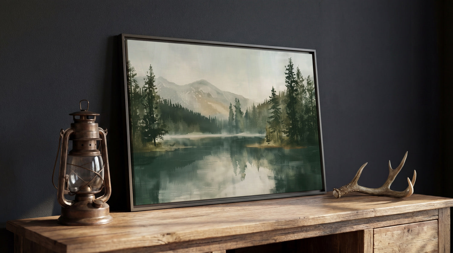 a framed painting of a serene mountain landscape with a lake, surrounded by pine trees and mountains. Next to the painting, there is a lantern and a pair of antlers, creating a rustic and cozy atmosphere.