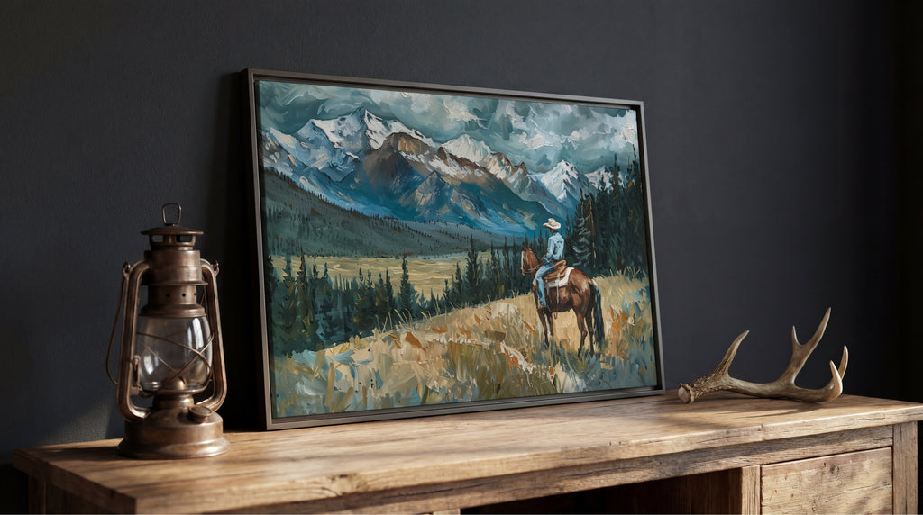 a painting of a cowboy riding a horse in a mountainous landscape, with a lantern and antlers on a wooden table in the foreground.