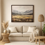 a cozy living room with a beige sofa, a woven side table, and a large landscape painting hanging on the wall above the sofa.