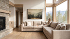 A woman sits on a large beige sectional sofa in a spacious living room, with a fireplace and large windows offering a scenic view of the mountains outside.