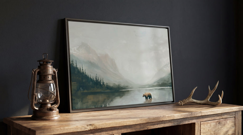 a painting of a bear standing in a lake, surrounded by mountains and trees, with a lantern and antlers on a wooden table in front of it.