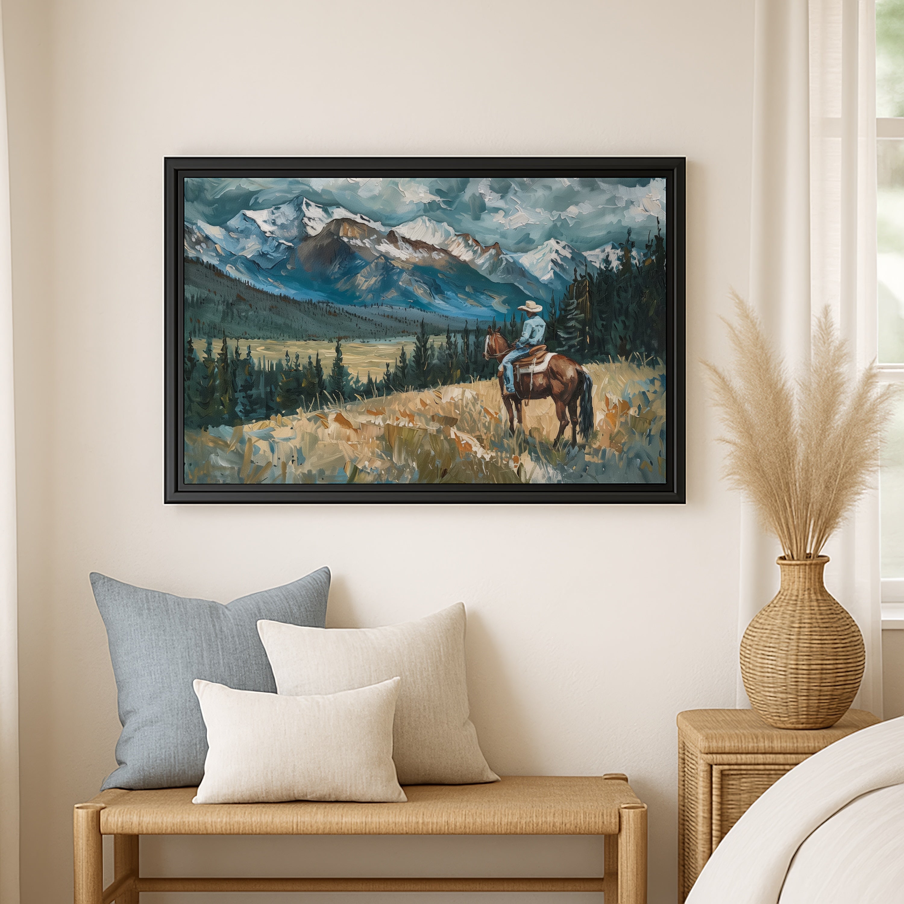 a painting of a cowboy riding a horse in a mountainous landscape, hanging on a wall above a wooden bench with pillows.