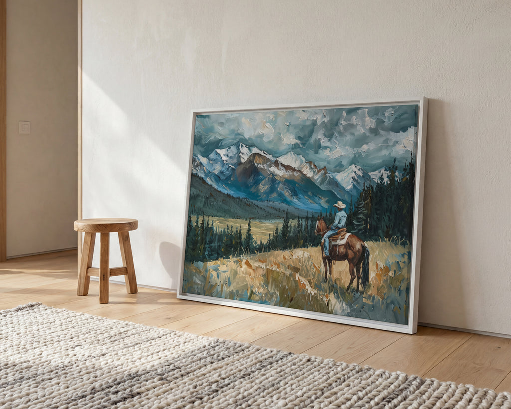 a large painting of a cowboy riding a horse in a mountainous landscape, with a wooden stool and a rug in the foreground.