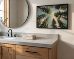 a bathroom vanity with a large mirror, a sink, and a framed painting of trees hanging on the wall above it.