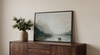 a wooden cabinet with a framed painting of a bear standing in a lake, surrounded by pine trees and mountains.