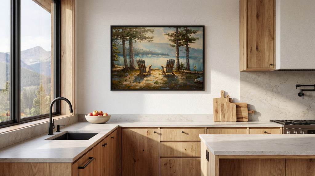 a serene kitchen scene with a large window overlooking a picturesque lake and mountains. The kitchen features wooden cabinets, a sink, and a countertop with a bowl of fruit. A framed painting of a lake and chairs is hanging on the wall above the sink.