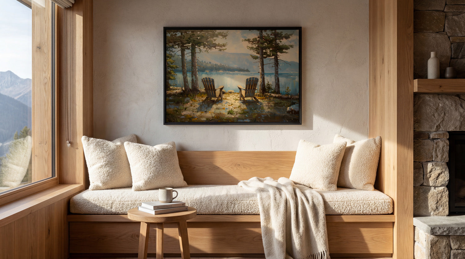 a cozy living room with a large window overlooking a scenic lake, a fireplace, and a painting of two chairs by the lake.