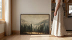 A woman in a long white skirt stands next to a large framed landscape painting depicting a forest scene with mountains in the background.