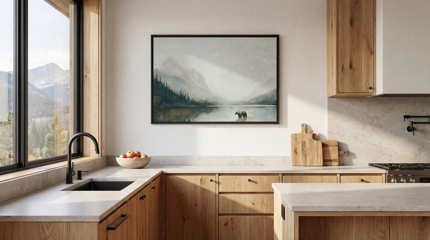 a modern kitchen with a large window overlooking a scenic mountain landscape. The kitchen features wooden cabinets, a black faucet, and a framed landscape painting on the wall.