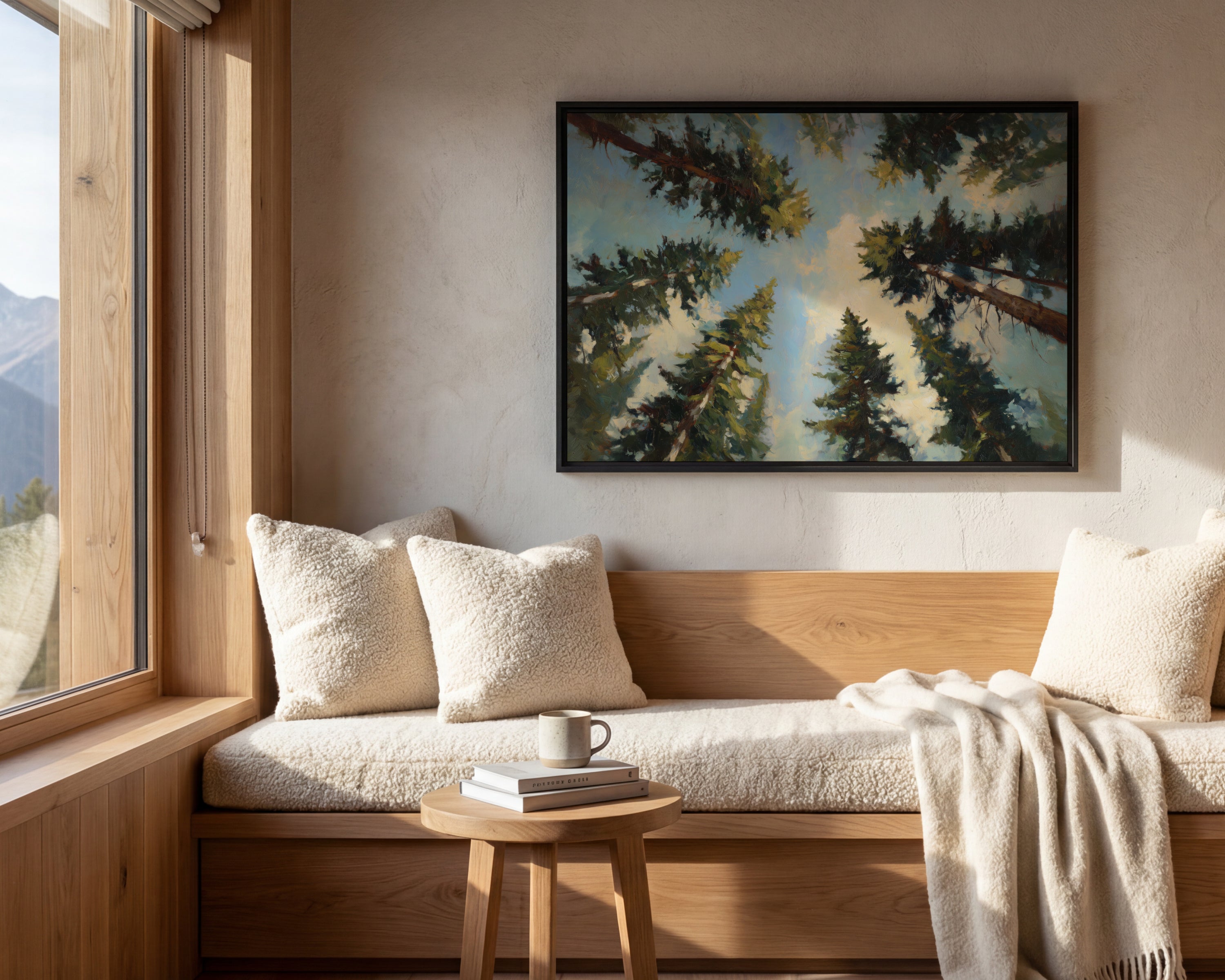 a cozy living room with a large window overlooking a scenic mountain landscape. The room features a wooden bench, a coffee table with a book and a mug, and a framed painting of a forest scene above the bench.