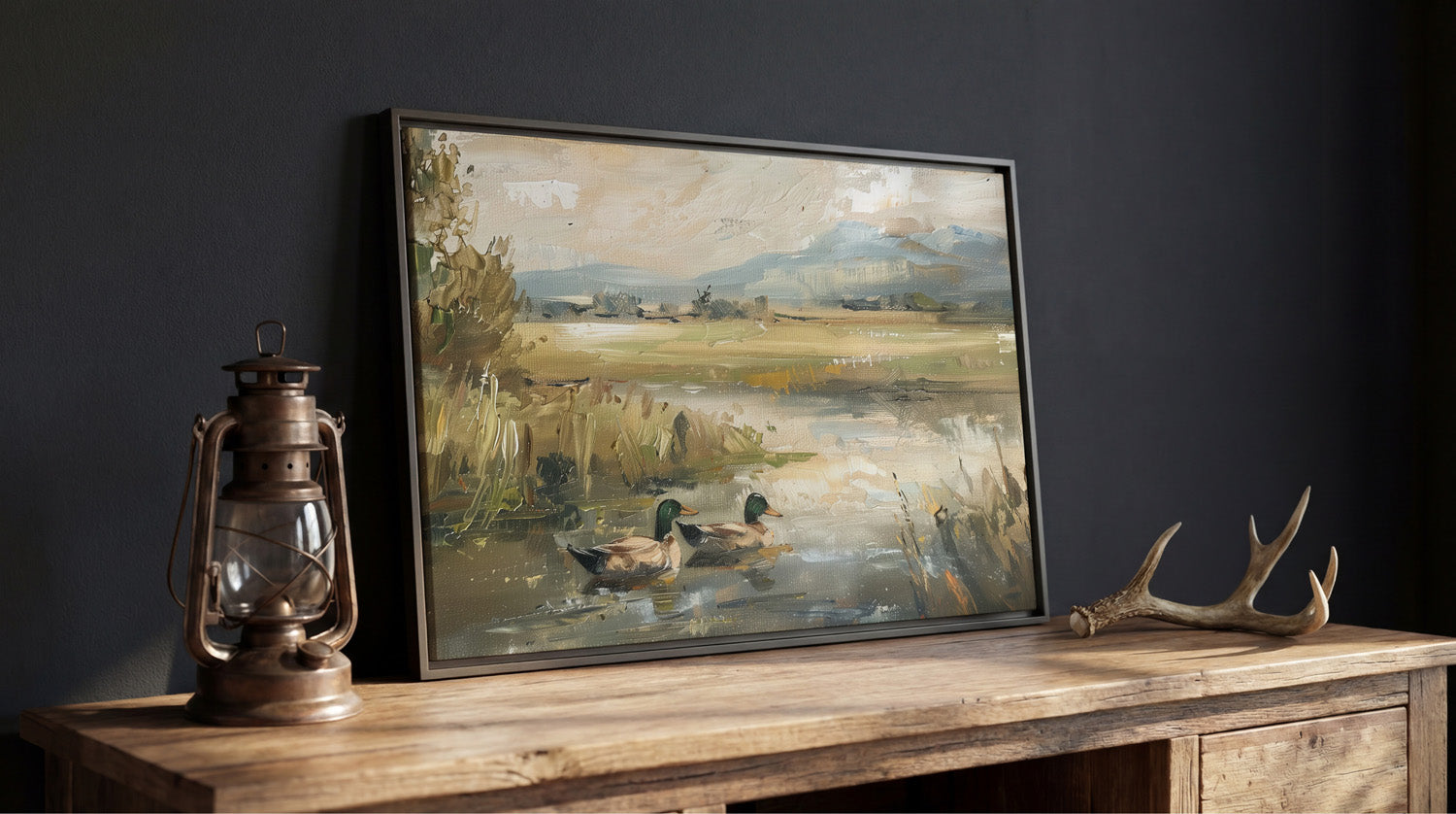 a painting of ducks swimming in a pond, displayed on a wooden table next to a lantern.