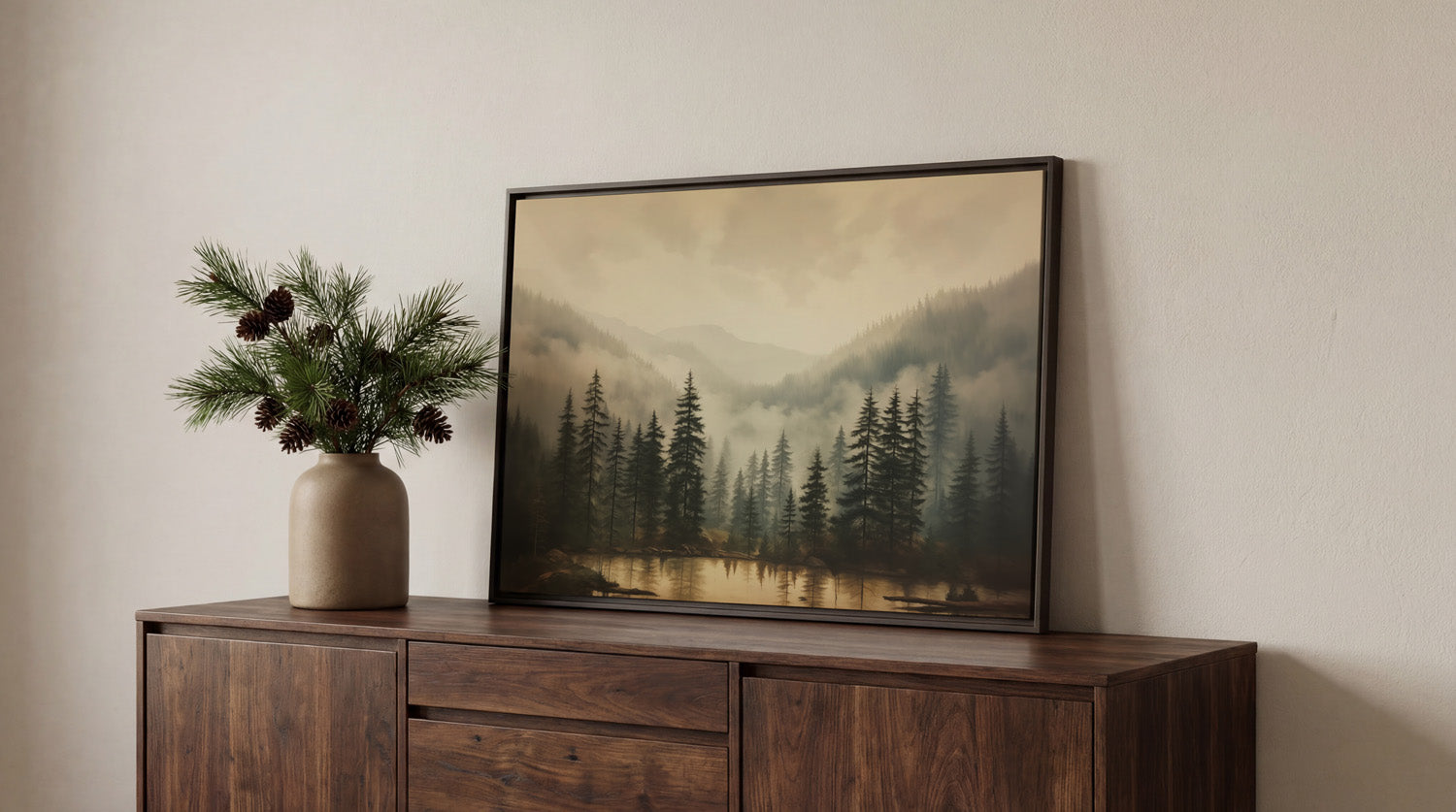 a wooden cabinet with a framed landscape painting hanging on it, depicting a serene forest scene with pine trees and a lake.
